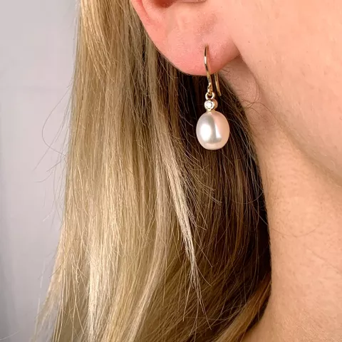 Ovale 8 - 9 mm aaa-graded ferskvandsperle øreringe i 14 karat guld med diamanter 