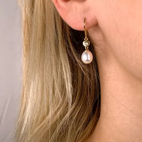 Ovale 7 - 8 mm aaa-graded ferskvandsperle øreringe i 14 karat guld med diamanter 