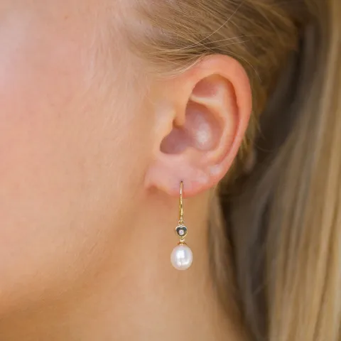 Ovale 7 - 8 mm aaa-graded ferskvandsperle øreringe i 14 karat guld med diamanter