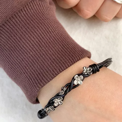 Sort armbånd i læder med blomstervedhæng i rhodineret sølv